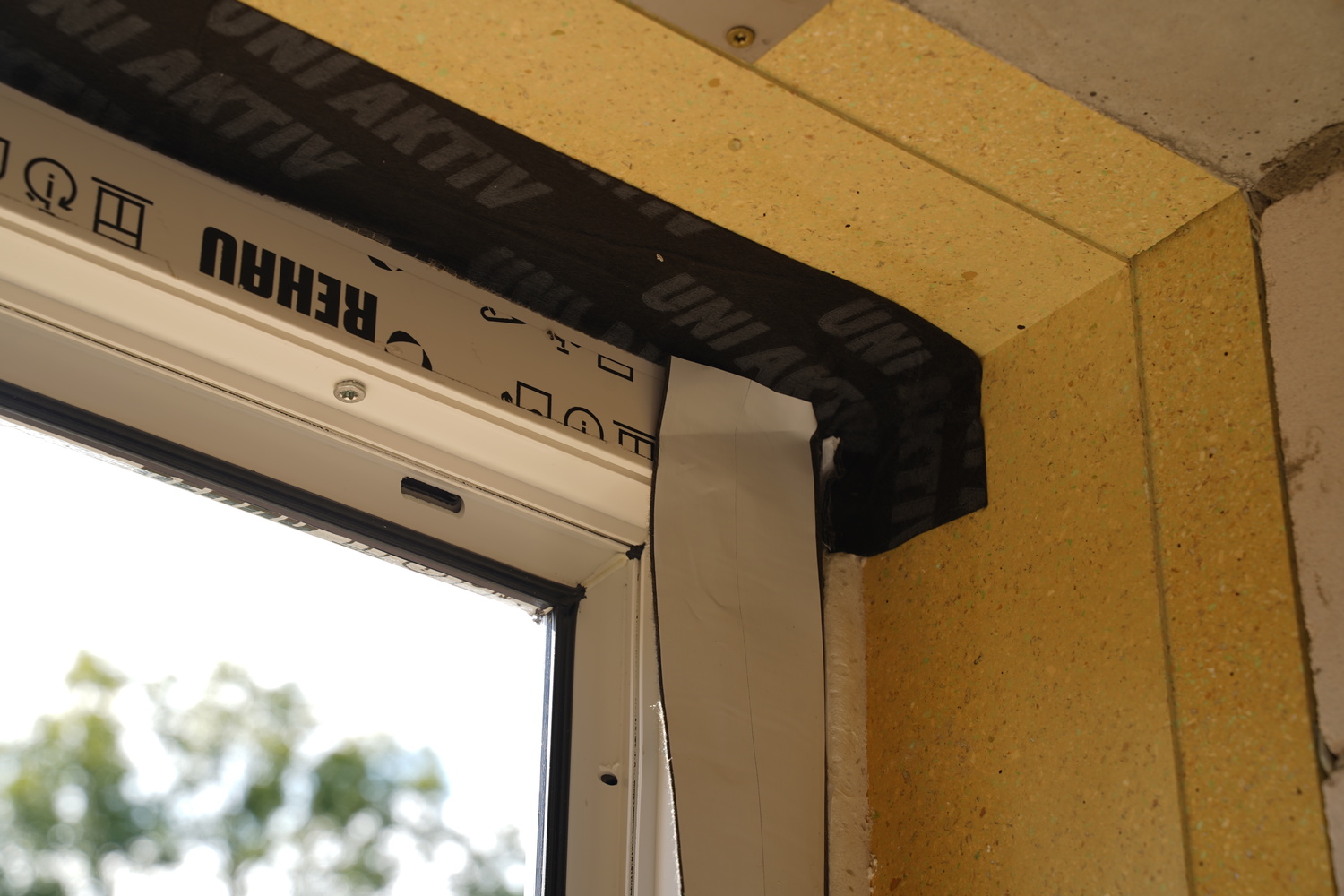 Gluing insulation tapes at the corners of the window
